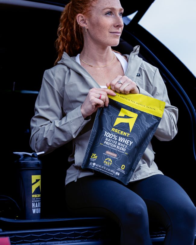 ascent protein athlete opening a bag of chocolate protein powder