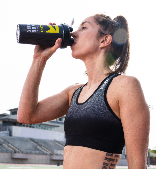 ascent protein athlete drinking from a protein powder blender bottle