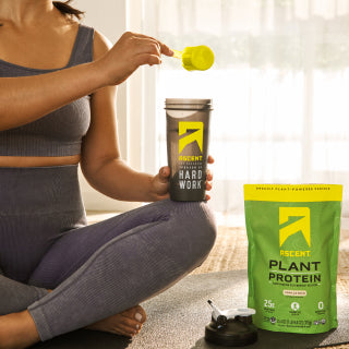 ascent protein athlete pouring a scoop pf protein powder into a blender bottle