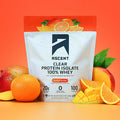 Ascent clear protein isolate package with oranges and mangoes on an orange background