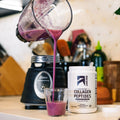 A purple smoothie is being poured from a blender into a small glass next to a white tub of Ascent Collagen Peptides in a kitchen setting.
split_row_banner_2