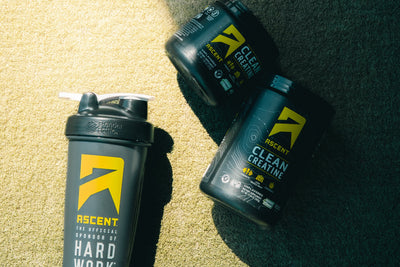 2 containers of Ascent Clean Creatine next to an Ascent shaker bottle