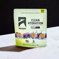 A stand-up pouch of Ascent Clean Hydration electrolyte drink mix in passionfruit flavor, standing on a white surface against a black background.