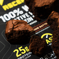 Chocolate brownies on a protein powder packaging with visible text and branding.