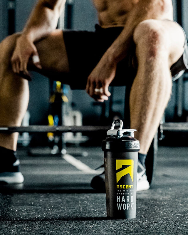 athlete sitting in a gym with an Ascent branded cup on the floor