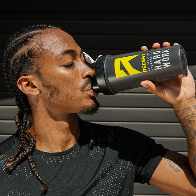 ascent protein athlete drinking protein powder from a ice shaker bottle